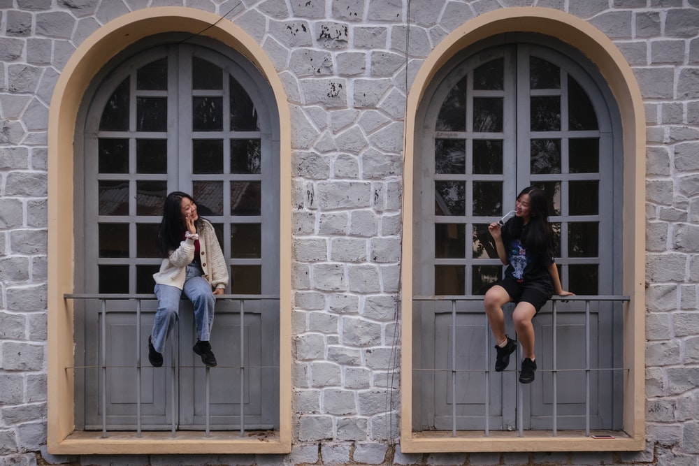 2 women sitting on window. Nguyen Thu Hoai https://unsplash.com/@thwhoai